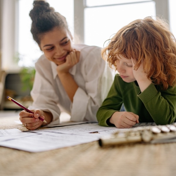 A tutor and a child looking over papers together